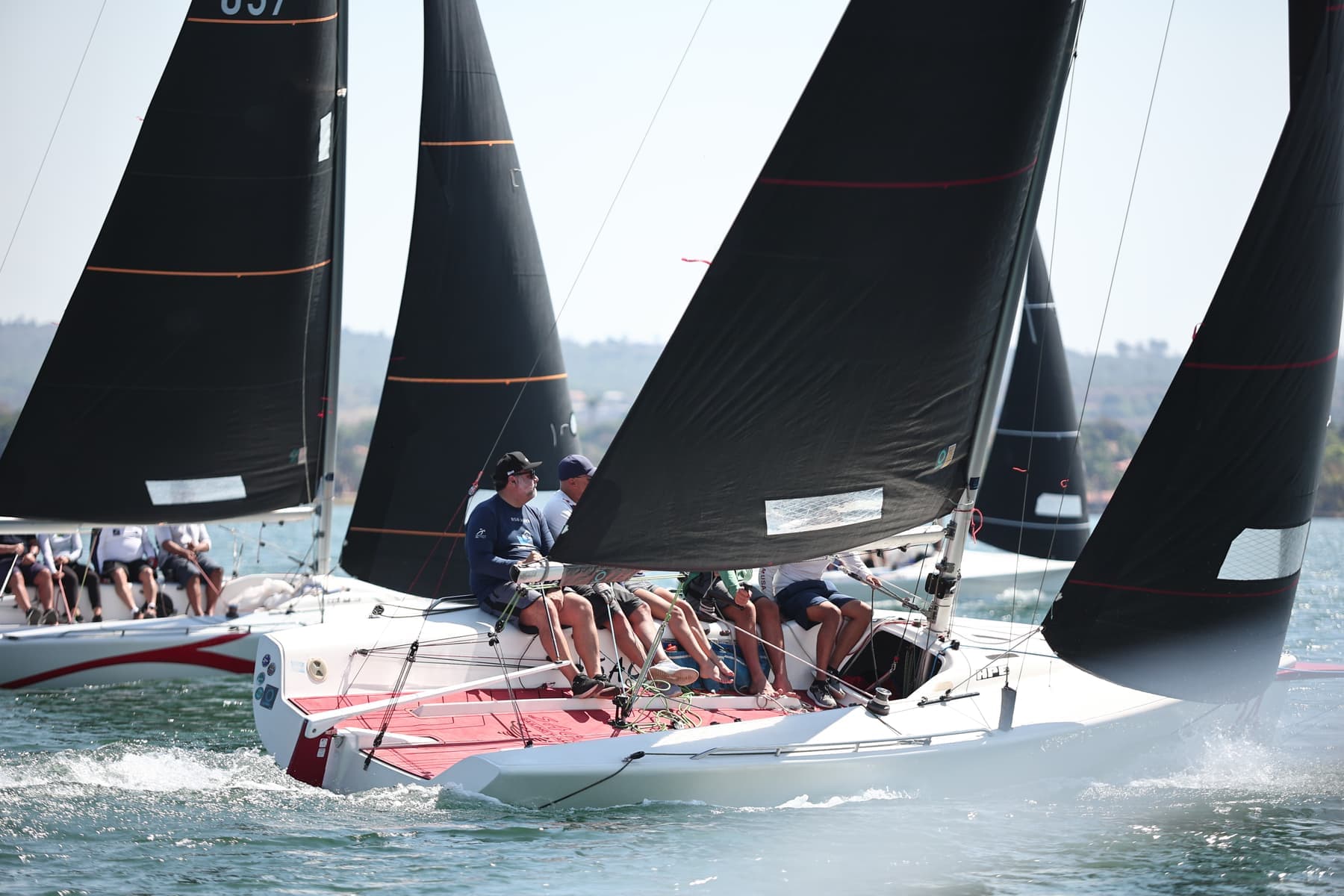 Barcos agrupados na subida da ceva, tripulações em posição de vante, água agitada entre os cascos